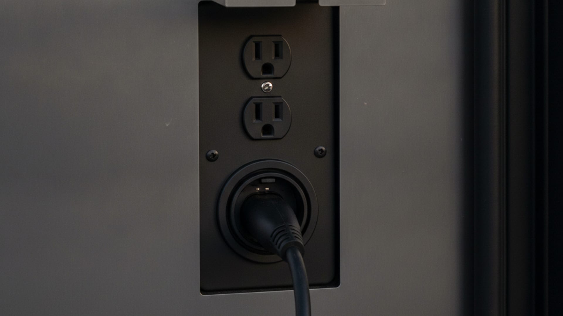 Mobile charging cable connected to a Tesla Model Y on a DC area street